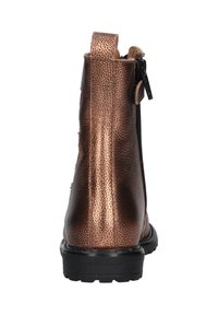 Botte métallique bronze à la cheville avec une finition texturée, dotée d'une fermeture éclair latérale, d'une languette et d'une semelle en caoutchouc noir durable.