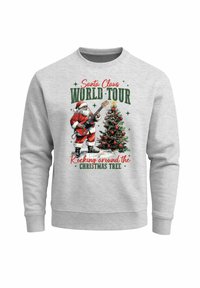 Grauer Pullover mit einem Motiv von Santa, der Gitarre neben einem geschmückten Weihnachtsbaum spielt. Der Text lautet "Santa Claus World Tour."