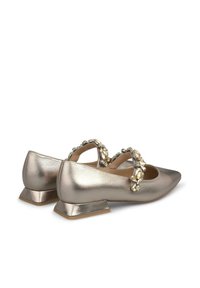 Chaussures plates argentées métalliques avec un bout pointu, dotées d'une sangle décorative ornée de pierres précieuses transparentes et d'un faible talon bloc.