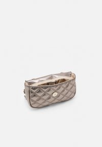 Prošívaná kovově bronzová kabelka s horním zipem a zlatým cvokem, která má hladkou vnitřní podšívku a jemné logo.