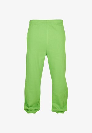 Roheline dressipüksid elastse vöökohtadega, kitsenevate pahkluudega ja siledast, kergest kangast. Lihtne disain, ilma nähtavate mustrite või aksessuaarideta.