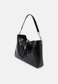 Bolso de mano de cuero negro con una textura suave, parte superior redondeada con un acento dorado y un diseño estructurado. La asa es elegante y negra.