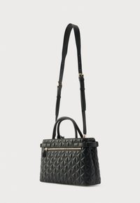 Czarna pikowana torebka o gładkiej fakturze, z podwójnymi górnymi uchwytami i regulowanym paskiem na ramię. Z przodu znajduje się kieszeń na zamek.