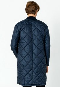 Marineblauer, gesteppten Langmantel mit einem strukturierten Rautenmuster, ausgestattet mit einem gerippten Kragen und einer lässigen Passform. Aus weichem, leichtem Stoff.