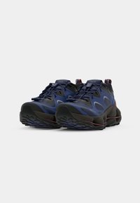Dunkelblaue Sneakers mit strukturiertem Obermaterial aus Stoff, Gummisohle und kontrastierenden dunklen Akzenten. Verfügt über einen Schnürverschluss und Ziehschlaufen.