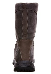 Bota de ante marrón con un forro suave, que presenta una parte trasera texturizada, costuras en contraste y una puntera redondeada sobre una suela de goma negra resistente.