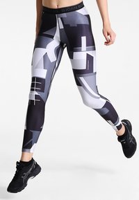 Leggings con un design aderente caratterizzati da motivi geometrici in tonalità di nero, grigio e bianco. Realizzati in materiale elasticizzato con una vita solida.