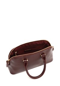 Sac à main en cuir marron avec une fermeture éclair. Dispose de deux poignées, d'une texture lisse et d'un intérieur doublé avec une petite poche.