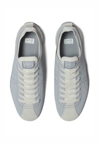 Jasnoniebieskie sneakersy z gładkiej skórzanej cholewki, białymi sznurówkami i gumową podeszwą. Posiadają żebrowany kołnierz i dekoracyjne przeszycia.