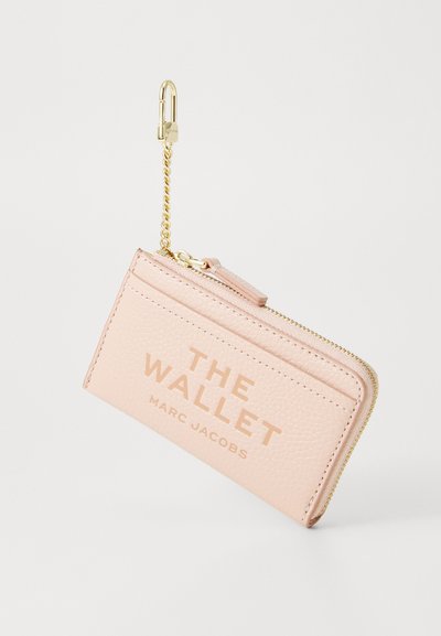Rozā akmens ādā veidota maciņš ar zelta rāvējslēdzēju, ķēdes cilpu un iepresētu tekstu "THE WALLET MARC JACOBS" priekšā.