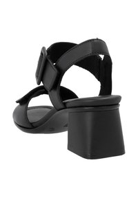 Black leather heeled sandal featuring a square block heel, adjustable buckle strap, and smooth texture. Open back design with minimal detailing.