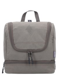 Zaino in tessuto grigio con una patta anteriore, doppie cerniere e una maniglia superiore. Presenta un logo sottile e una superficie testurizzata. Design compatto.