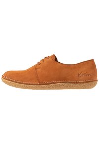 Chaussure décontractée en suede marron à lacets avec semelle en caoutchouc texturée, profil bas et logo Kickers sur le côté du talon.