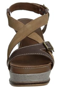 Sandales en suede marron et beige à talon compensé avec des sangles croisées, détail de boucle et semelle texturée en ton argenté, avec des accents cousus.