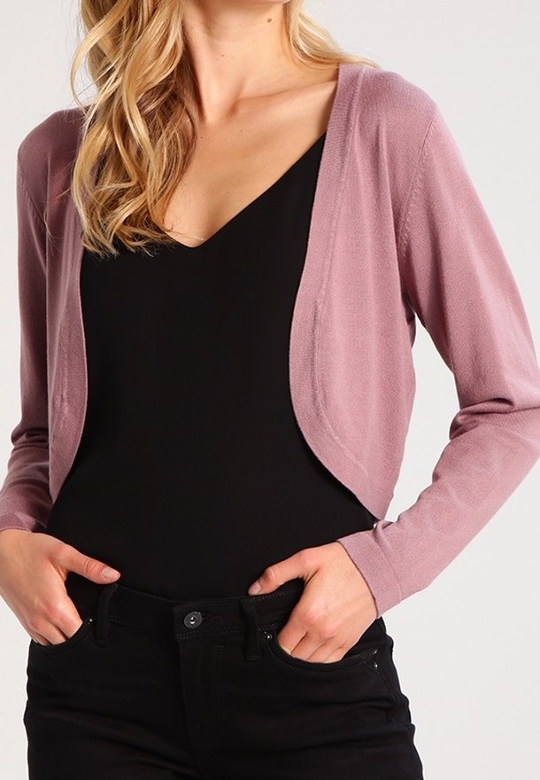 Cárdigan corto rosa de material de punto ligero con escote en V, diseño de frente abierto y mangas largas, combinado con una camiseta negra y jeans.