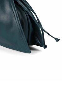 Handtas van tealleer met een driehoekige vorm, voorzien van een zachte textuur en een trekkoordsluiting met koordbandjes en stikseldetails.