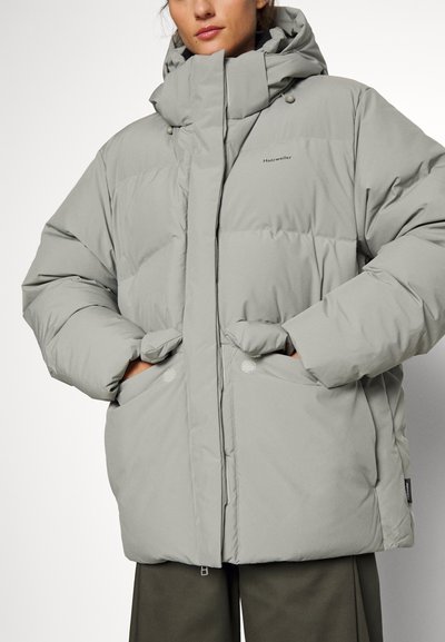 Polstret grå jakke med høj krave og hætte, med frontlommer og knaplukninger; glat tekstur og oversized design.