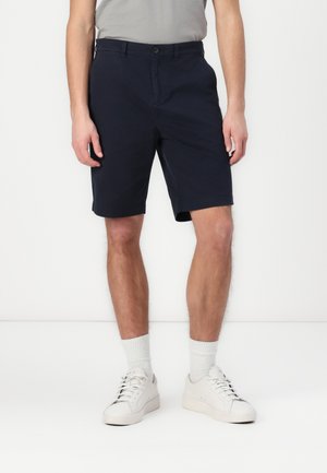 Marina blå shorts tillverkade av bomullstyg med knäppning; har sidofickor och rak skärning ovanför knäet.