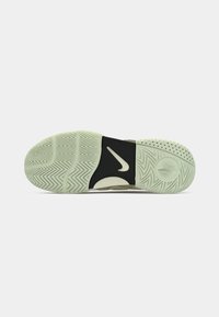 Nike sporta apavu zole gaiši zaļā krāsā ar rakstainu protektoru, melna vidus zole ar logotipu un teksturētām akcentiem. Redzamas izliekta un plakana virsma.