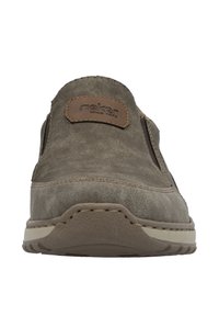 Dark gray slip-on shoe with a smooth textured upper, brown leather accent patch, rubber sole, and contrasting white stitching.