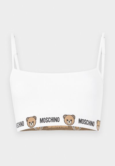 Λευκό crop top με λεπτές τιράντες, με καφέ αρκουδάκι και επαναλαμβανόμενο κείμενο "MOSCHINO" κατά μήκος της κάτω ταινίας.