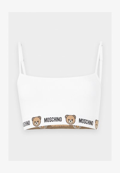 Λευκό crop top με λεπτές τιράντες, με καφέ αρκουδάκι και επαναλαμβανόμενο κείμενο "MOSCHINO" κατά μήκος της κάτω ταινίας.