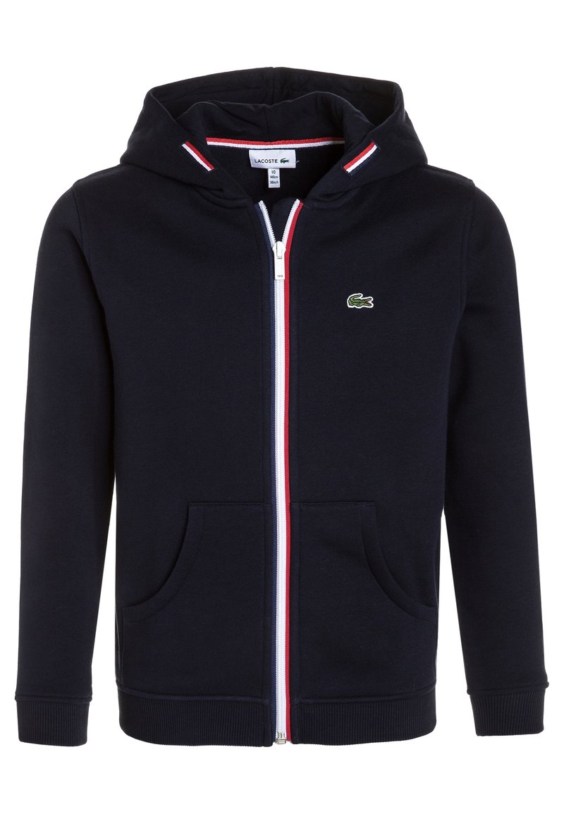 Sudadera con capucha azul marino con un acento en rojo y blanco a rayas, bolsillos tipo canguro y un logo bordado en verde en el lado izquierdo del pecho. Tejido texturizado.
