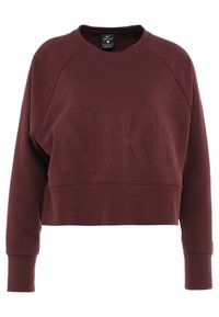 Sudadera Nike Dri-FIT en color burdeos con diseño corto, mangas raglán y logotipo embossado en la parte frontal, fabricada con una tela suave y lisa.