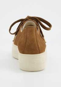 Baskets en daim marron avec un bout arrondi, surface texturée, semelle en caoutchouc crème et design à lacets. Présente de subtils accents dorés au niveau du talon.