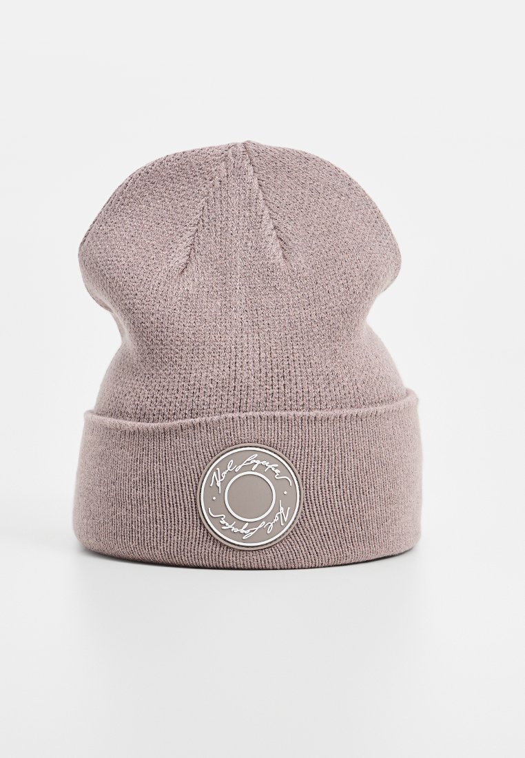 Gebreide roze beanie met een omgevouwen rand, voorzien van een rond merkembleem aan de voorkant. Gladde textuur met een aansluitend ontwerp.