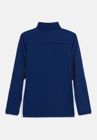 Μπλε ναυτικό μακρυμάνικο πουλόβερ με ψηλό γιακά και λευκές και μαύρες πλαϊνές επιφάνειες, που διαθέτουν λεπτή ροζ ρίγα κοντά στο κάτω μέρος.