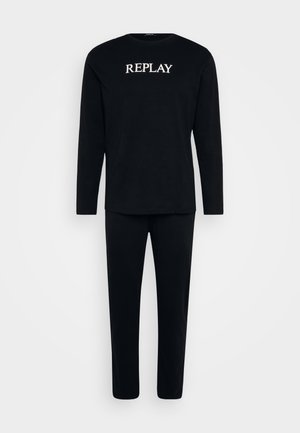 Svart långärmad topp och matchande byxor i mjukt tyg. Toppen har en vit "REPLAY"-logotyp över bröstet. Enkel, strukturerad design.