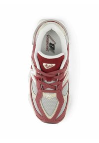 Zapatilla roja y gris con material de malla y gamuza; cuenta con un cuello acolchado, sistema de cordones y el logotipo de New Balance en el lateral.