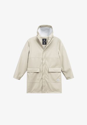 Béžový vodeodolný kabát s vysokým golierom, cvokovými uzávermi, dvoma prednými vreckami a logom na dolnom pravej strane. Hladká textúra.
