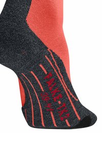 Zbliżenie stopy w czarno-pomarańczowej skarpecie z napisem "WALKER 39-42" oraz detalami amortyzacji na podeszwie i pięcie.