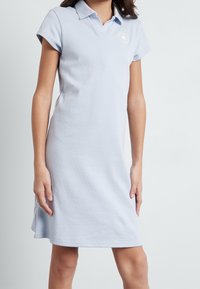 Polo jurk in lichtblauwe katoen, korte mouwen, klassieke kraag en een logo-patch op de borst; knie-lengte met een relaxed fit.