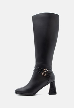Knæhøj sort læderstøvle med spids tå, to dekorative remme med guld spænder og en kraftig, tekstureret hæl.