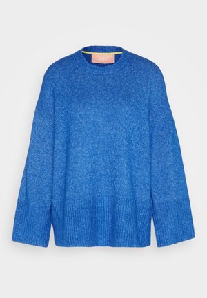 Blå strikket sweater med lange, vide ærmer, ribbede manchetter og kant samt rund halsudskæring, vist på en ensfarvet lys baggrund.