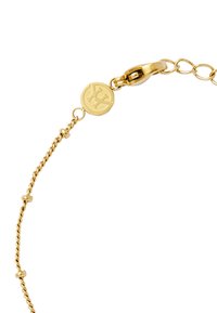 Bracciale d'oro con un design a catena attorcigliata, etichetta circolare con logo e chiusura sicura. Texture liscia con accentuazioni arrotondate.