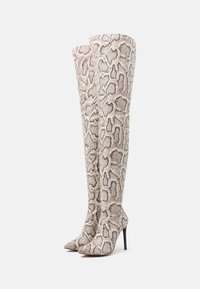 Botas por encima de la rodilla hechas de material con estampado de serpiente en tonos beige y marrón, con punta afilada y diseño de tacón de aguja.