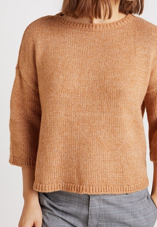 Hellbrauner Strickpullover mit rundem Ausschnitt und dreiviertellangen Ärmeln. Die Textur wirkt weich und dick, mit einem gerippten Saum.