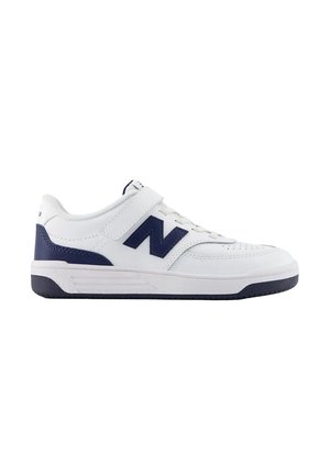 Sneaker basse bianche e blu navy con strap in Velcro, chiusura frontale con lacci e suola spessa, mostrata di lato su sfondo bianco.