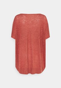Tričko s krátkým rukávem a volným střihem ve vybledlé rezavé barvě. Měkká, texturovaná pletenina. Má široký výstřih a zaoblený spodní lem.