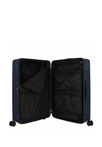 Valigia rigida di colore blu navy con texture a coste verticali, aperta per mostrare l'interno nero con diversi scomparti e una tasca con zip.