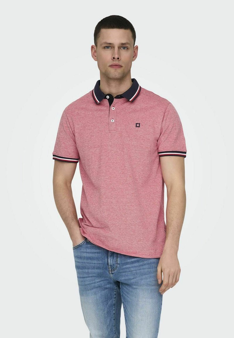 Polo shirt rosso a maniche corte con colletto blu navy a contrasto e dettagli a righe, dotato di logo sul petto e una vestibilità comoda.