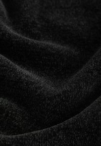 Black fleece fabric with a soft, textured surface, showing a subtle sheen and gentle folds. No visible patterns or accents.