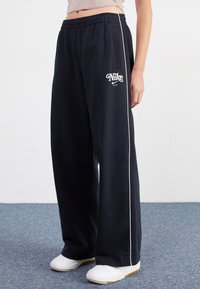 Nike Sportswear STRAIGHT PANT - Tracksuit bottoms - black
