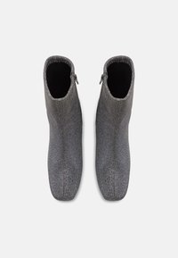 Grå tekstil ankelstøvler med en glatt overflate, spiss tå og glidelåser på siden for enkel påkledning. Har en tett passform og minimalistisk design.
