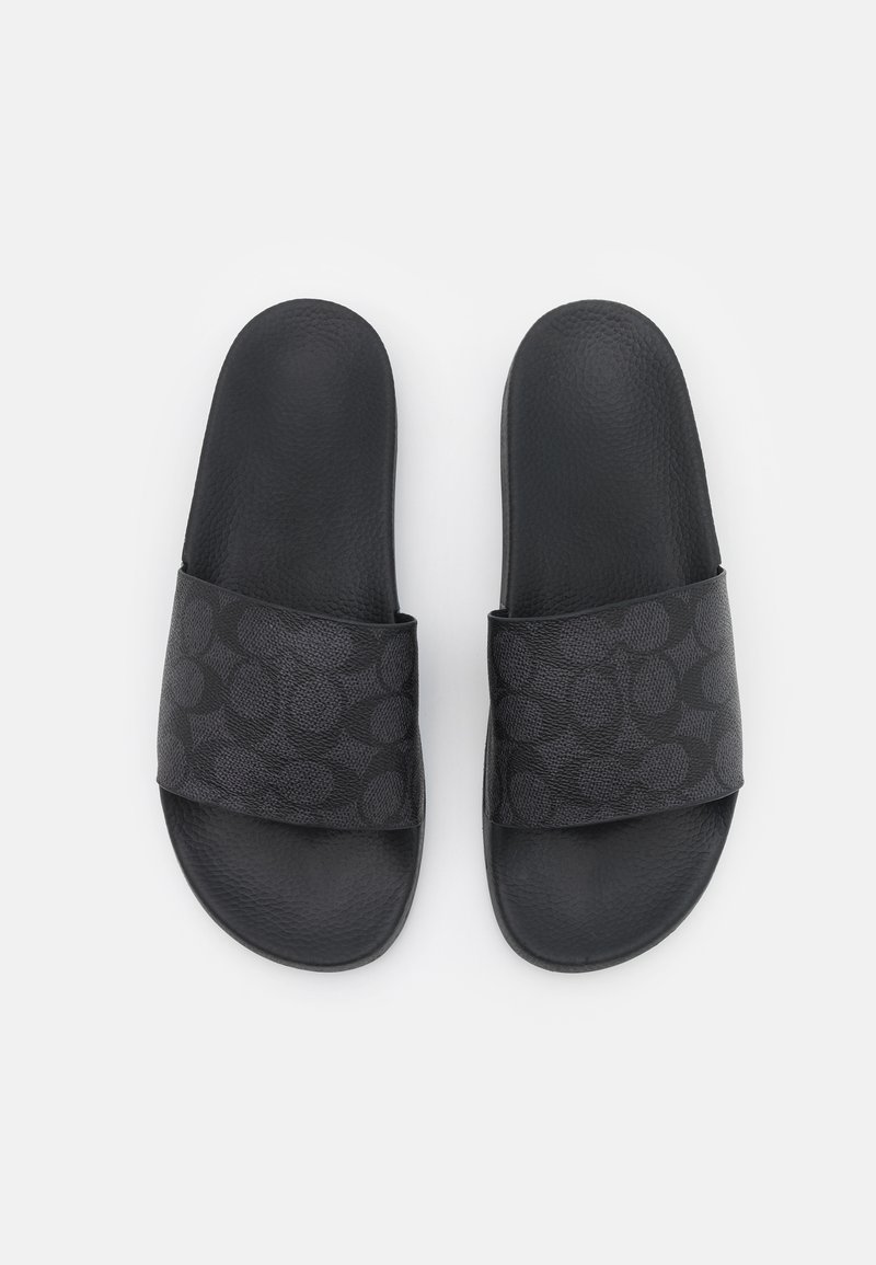 Black slide sandals featuring a textured strap with a dark circular pattern and a smooth matte footbed. Designed for casual wear.