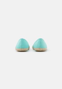 Sapatos em lona turquesa, tipo slip-on, com bico arredondado e sola texturizada de juta, apresentando detalhes de acentuação mínimos.
